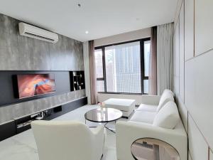 a living room with white furniture and a tv at Pavillion @ 8 Kia Peng #10mins walk Pavillion klcc in Kuala Lumpur