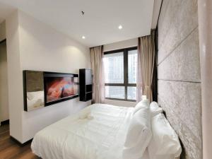 Schlafzimmer mit einem weißen Bett und einem Flachbild-TV in der Unterkunft Pavillion @ 8 Kia Peng #10mins walk Pavillion klcc in Kuala Lumpur