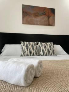 1 dormitorio con 1 cama blanca y una pintura en la pared en Coco Luxury Loft, en Cancún