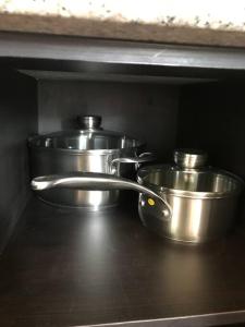 dos ollas de acero inoxidable sentadas en un estante en Acogedora cabaña - en Alto Boquete, full equipada, en Alto Boquete
