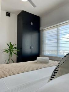 1 dormitorio con cama, planta y ventana en Coco Luxury Loft, en Cancún