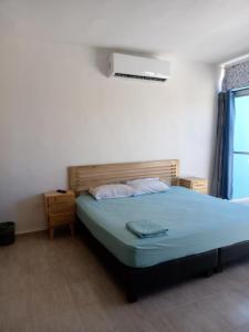 Schlafzimmer mit einem Bett mit blauer Bettwäsche und einem Fenster in der Unterkunft Casa Alegre Yucatan in Kanasín