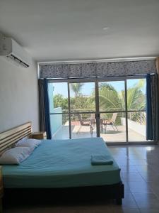 Schlafzimmer mit einem Bett und Blick auf einen Innenhof in der Unterkunft Casa Alegre Yucatan in Kanasín