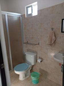 a bathroom with a toilet and a shower and a sink at Casa Alegre Yucatan in Kanasín