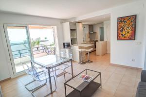 a living room with a glass table and chairs at Balmins White by Hello Homes Sitges in Sitges