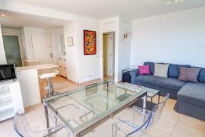 a living room with a glass table and a couch at Balmins White by Hello Homes Sitges in Sitges