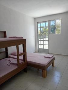 Zimmer mit 2 Etagenbetten und einem Fenster in der Unterkunft Casa Alegre Yucatan in Kanasín