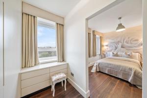 a bedroom with a bed and a large window at Relax, Play and Work in London in London