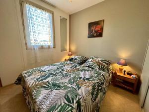 ein Schlafzimmer mit einem Bett und einem Tisch mit Lampen in der Unterkunft Appartement Saint-Cyprien, 2 pièces, 6 personnes - FR-1-225D-209 in Saint-Cyprien