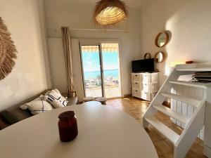 uma sala de estar com uma mesa branca e vista para o oceano em Appartement Rayol-Canadel-sur-Mer, 2 pièces, 4 personnes - FR-1-226B-189 em Rayol-Canadel-sur-Mer