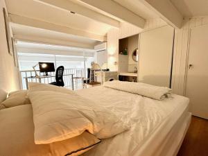 um quarto com uma grande cama branca num quarto em Appartement Rayol-Canadel-sur-Mer, 2 pièces, 4 personnes - FR-1-226B-189 em Rayol-Canadel-sur-Mer