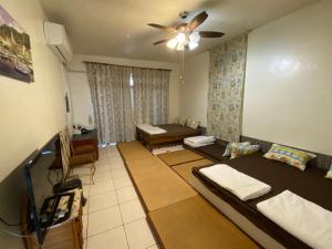 a living room with two beds and a ceiling fan at 以諾亞的家 in Linbian