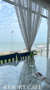 Lovita Tanjung Bidara Beach Resort في ميلاكا: طاولة مطلة على الشاطئ والمحيط