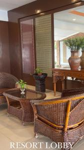 a room with wicker chairs and a table and a mirror at Lovita Tanjung Bidara Beach Resort in Melaka