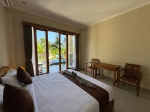 a bedroom with a bed and a view of a pool at Canggu Nadi 2 Guest House in Canggu