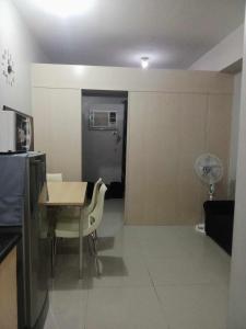 a living room with a table and chairs and a kitchen at Grass residence tower3 30th Floor in Manila