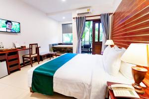 Green Amazon Residence Hotel في سيام ريب: غرفة نوم مع سرير ومكتب مع جهاز كمبيوتر