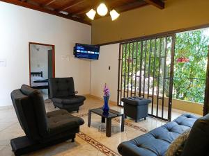 een woonkamer met een bank en stoelen en een tv bij !Hermosa Casa en el Mejor lugar de Medellín! in Envigado