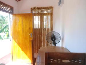 a room with a door with a fan and a table at SUPER SUN HOMESTAY in Katugastota