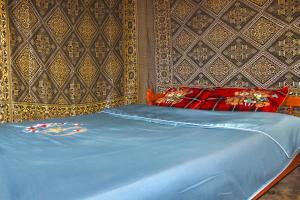een bed met blauwe lakens en rode kussens in een slaapkamer bij Sapa Hillcrest homestay in Lao Cai