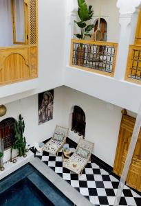 une chambre avec une piscine et deux chaises dans l'établissement Riad LallaBaya, à Marrakech