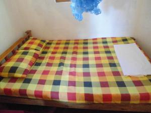 a bed with a checkered blanket on it at SUPER SUN HOMESTAY in Katugastota