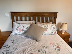 a bed with a wooden headboard and two pillows at Mountain Tranquility in Mount Tomah