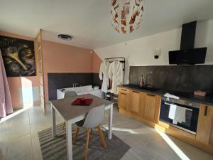 a kitchen with a table and a bath tub at Suite Love et Evasion in Saint-André-le-Gaz