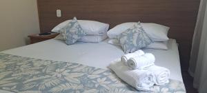 a bedroom with a bed with towels on it at Hotel Orleans in Petrópolis