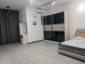 an empty room with a bed and a refrigerator at CEM MIRI HOMESTAY in Miri