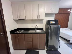 a small kitchen with a sink and a refrigerator at One Palm Tree villas with free parking in Manila