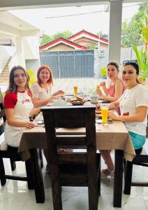 un grupo de mujeres sentadas en una mesa en Funwhales Rest House, en Negombo