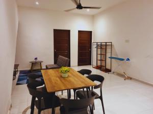 - une salle à manger avec une table et des chaises en bois dans l'établissement Bilik & Rumah Tamu Ketereh, à Ketereh