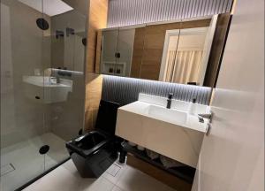 a bathroom with a sink and a mirror and a toilet at Studio fácil acesso a paulista in Sao Paulo