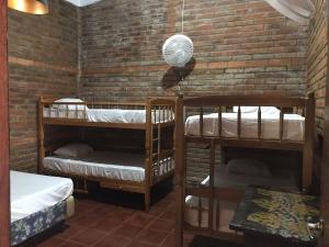 a room with two bunk beds and a brick wall at Casa Vieja Surf Spa Mizata in La Libertad