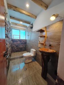 y baño con aseo y lavamanos. en Villa Maru, en Calca