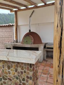 una cocina con horno de pizza en un edificio en Villa Maru, en Calca