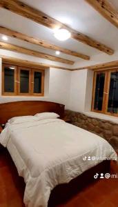 1 dormitorio con 1 cama blanca grande y ventanas en Villa Maru, en Calca