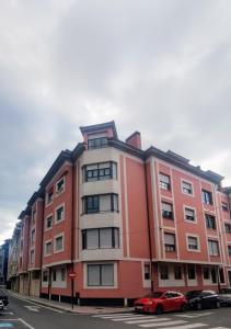 a red building with cars parked in front of it at REY AURELIO 2 in Cangas de Onís