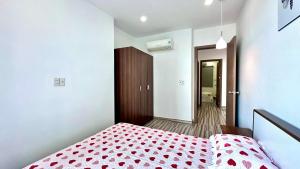 - une chambre avec un lit doté d'une couverture rouge en point de polka dans l'établissement LUCA House, à Nha Trang