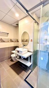 La salle de bains est pourvue d'un lavabo et d'une douche. dans l'établissement LUCA House, à Nha Trang