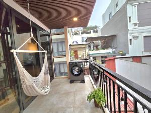 a porch with a hammock and a washing machine on a balcony at The Shilla Apartment in Hanoi
