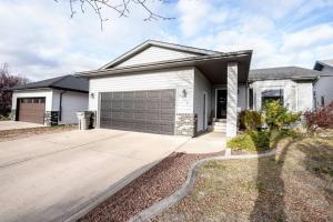 a white house with a garage at Bright and Spacious Home away from home in Grande Prairie