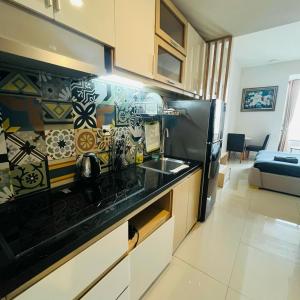 een keuken met een wastafel en een zwarte koelkast bij Mark Apartment - Millennium Masteri in Ho Chi Minh-stad