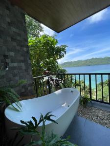 a bath tub sitting on a balcony overlooking the water at Bugana Beach and Dive Resort in Manlocahoc