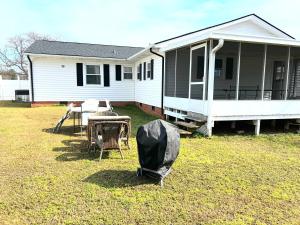a house with a table and chairs in the yard at Kids,Pets, friendly 3BR 2BT Game Bonus, Room Fenced in Fayetteville