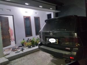 Czarny SUV zaparkowany przed domem w obiekcie Almahyra Homestay Syariah w mieście Bukittinggi