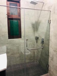 a shower with a glass door in a bathroom at Lolu Village Resort in Anuradhapura