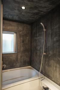 a bathroom with a bath tub and a window at SOUQ in Himeji