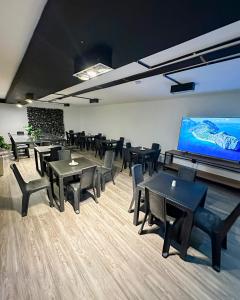 a room with tables and chairs and a large screen at Inizio Hotel Boutique Laureles in Medellín